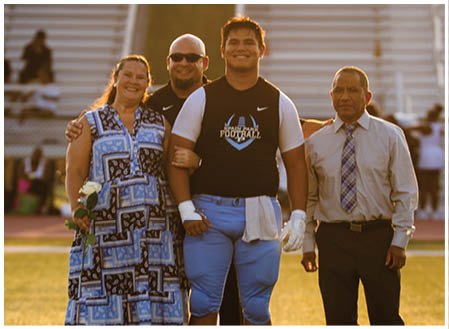 A group of people posing for a photo on a football field. AI generated content