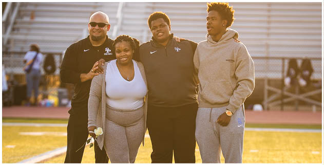 Three people are standing on a field, posing for a photo. One person is wearing a white shirt, another is wearing a black shirt, and the third person is wearing a gray shirt. The group appears to be friends or teammates, possibly participating in a sports event. AI generated content