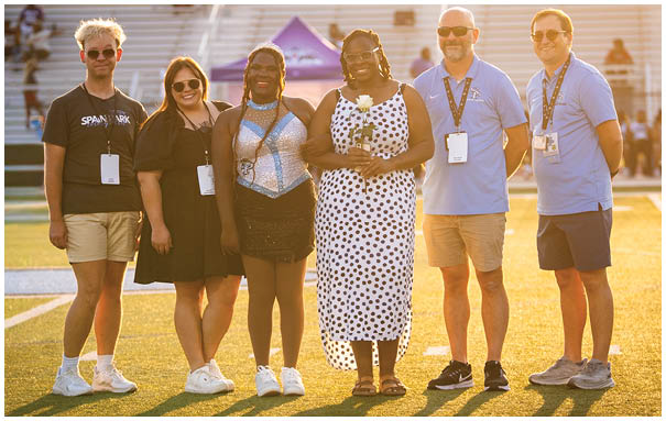 A group of people posing for a photo on a field. AI generated content