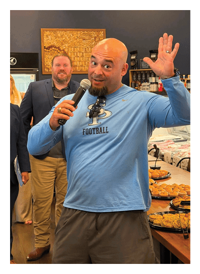 A man wearing a blue shirt and sunglasses is speaking into a microphone. AI generated content