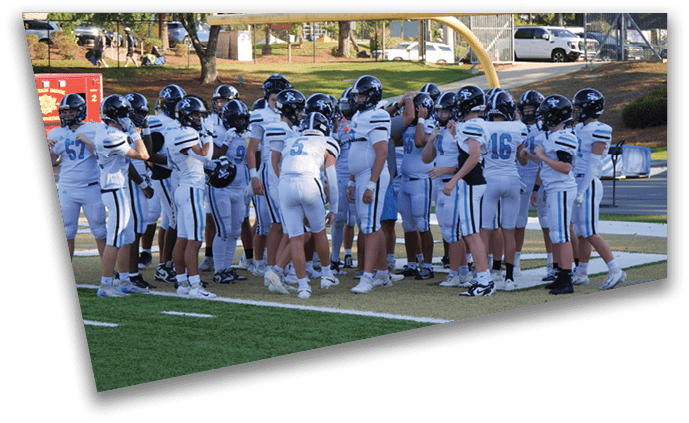 A group of football players wearing white uniforms are gathered on the field. AI generated content