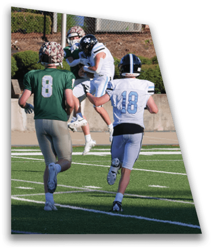 Two men are running on a field, one wearing a green jersey and the other wearing a blue jersey. They are both running towards a football. AI generated content