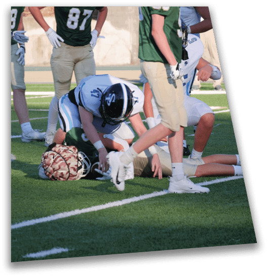 A group of football players on a field, one player is kneeling down and another is bending over him. AI generated content