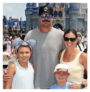 A man, woman, and two children pose for a picture in front of a castle. AI generated content