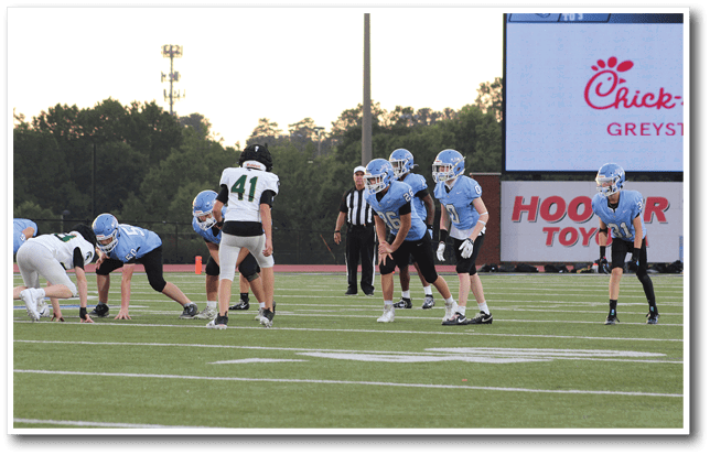 A group of football players in blue and white uniforms are on the field. AI generated content