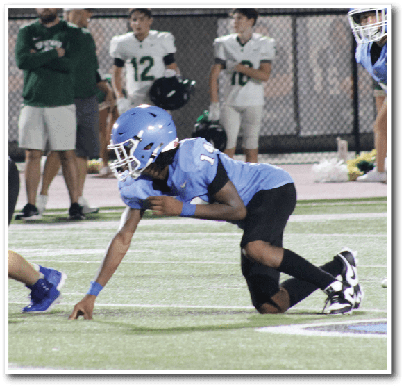 A football player wearing a blue helmet is being patted on the back by a coach. AI generated content