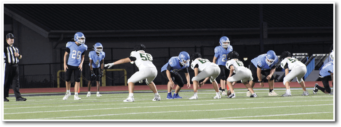 A group of football players are lined up on the field, preparing for a play. AI generated content