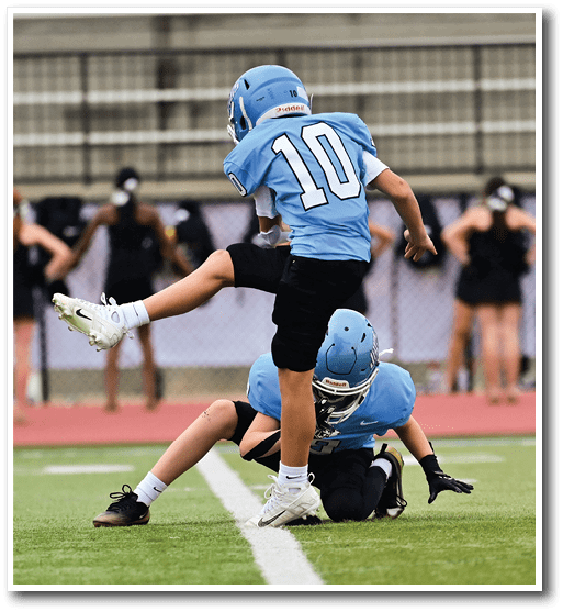 A football player is kicking a ball on the field while other players watch. AI generated content