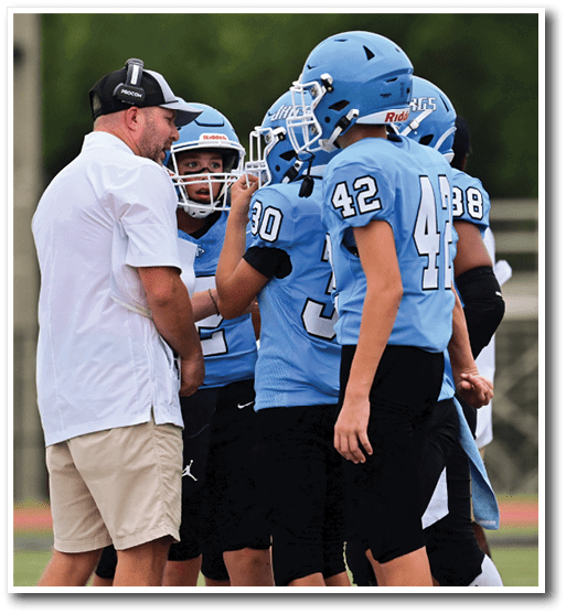A group of young men wearing blue jerseys are standing on a field. AI generated content