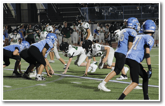 A group of football players in blue and white uniforms are on the field. AI generated content