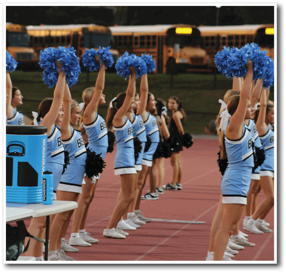A group of cheerleaders in blue and white uniforms are holding blue and white pom poms. AI generated content