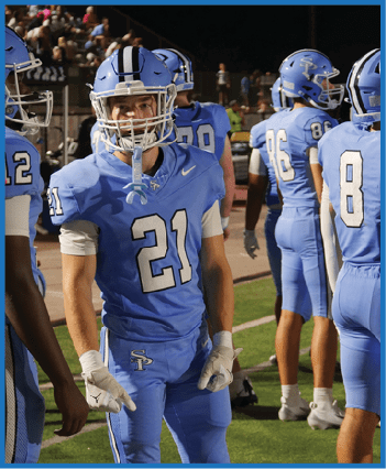 A group of football players in blue uniforms are standing on a field. AI generated content