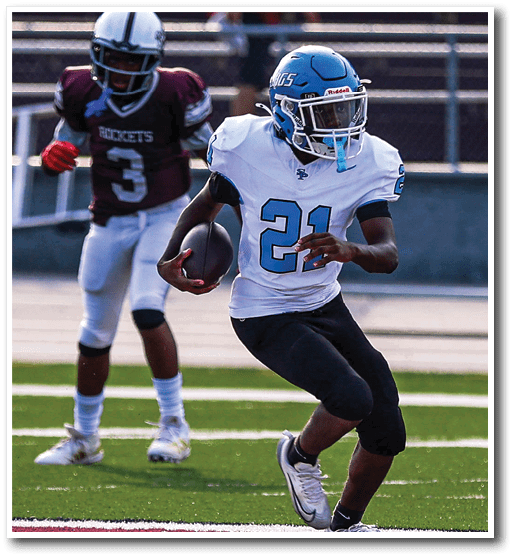 A person in a white and blue football uniform is running with the ball while another person in a maroon and white uniform is chasing behind on a football field. Description generated by AI