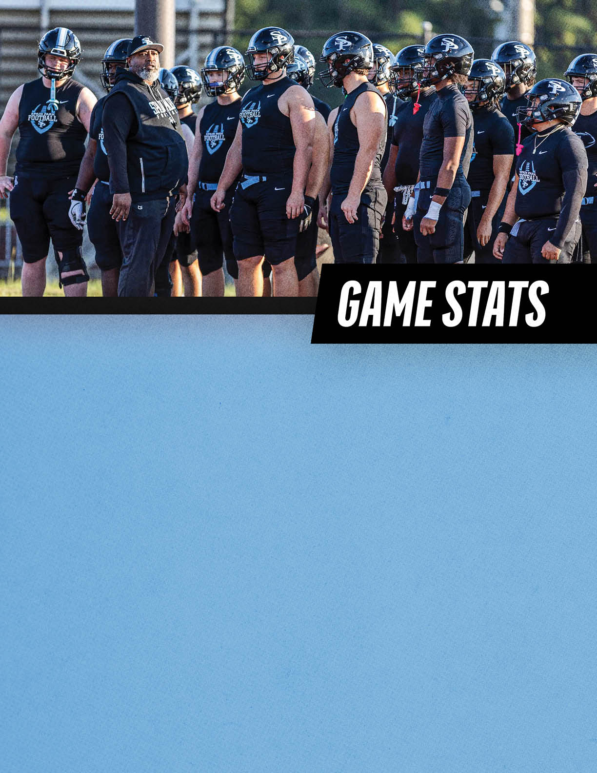 A group of people wearing black sports uniforms and helmets stand together on a field with a coach giving instructions. Description generated by AI