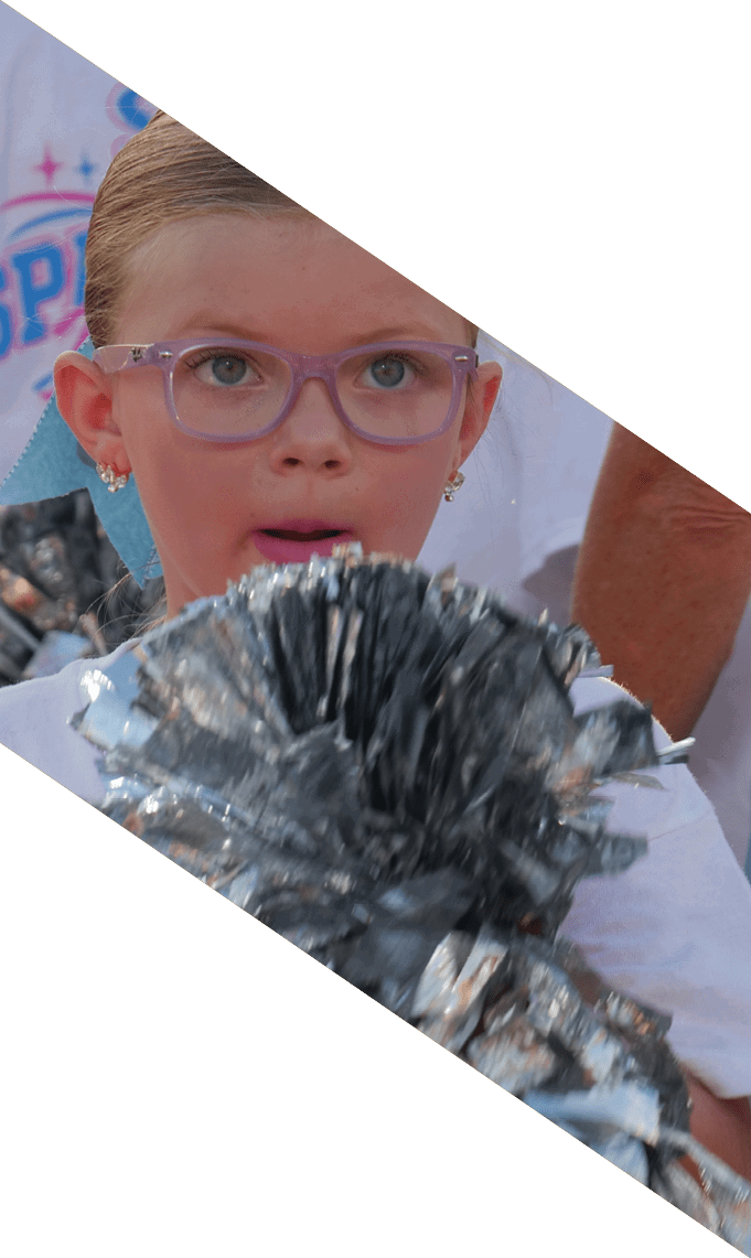 People wearing white shirts hold silver pom-poms, suggesting they are participating in a cheerleading or spirit event. Description generated by AI
