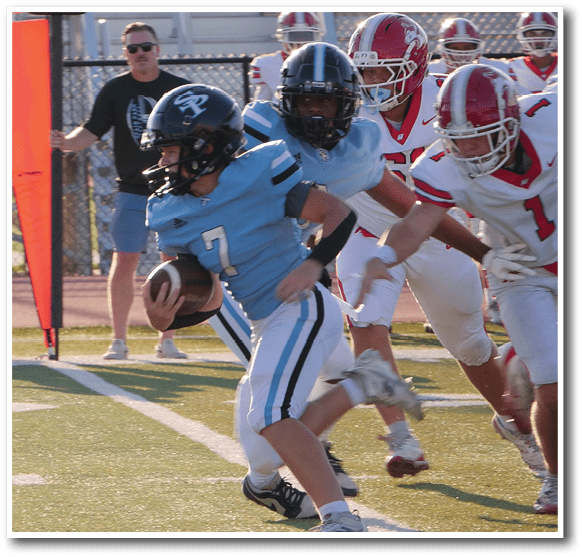 People in football uniforms are actively playing on a field near a down marker showing second down. Description generated by AI