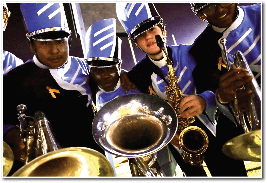 Three people in marching band uniforms are holding brass and woodwind instruments while posing closely together. Description generated by AI