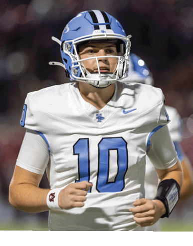 A person wearing a white football uniform with the number 10 and a blue helmet is running on a field during a game. Description generated by AI