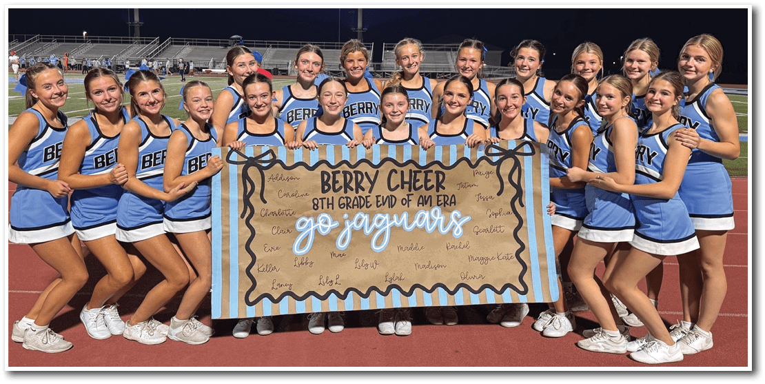 A group of cheerleaders in blue and white uniforms stand on a track holding a large banner that reads “Berry Cheer 8th Grade End of America Go Jaguars" with signatures and messages written on it. Description generated by AI