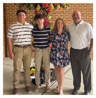 A family poses for a picture in front of a flower arrangement. AI generated content