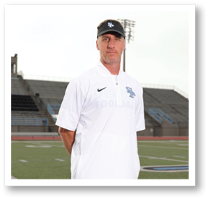 A man wearing a white shirt and a blue hat stands on a football field. AI generated content