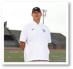 A man wearing a white shirt and black hat stands on a field. AI generated content