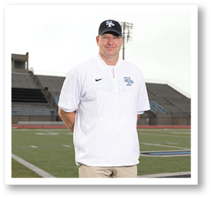 A man wearing a white shirt and a black hat stands on a football field. AI generated content