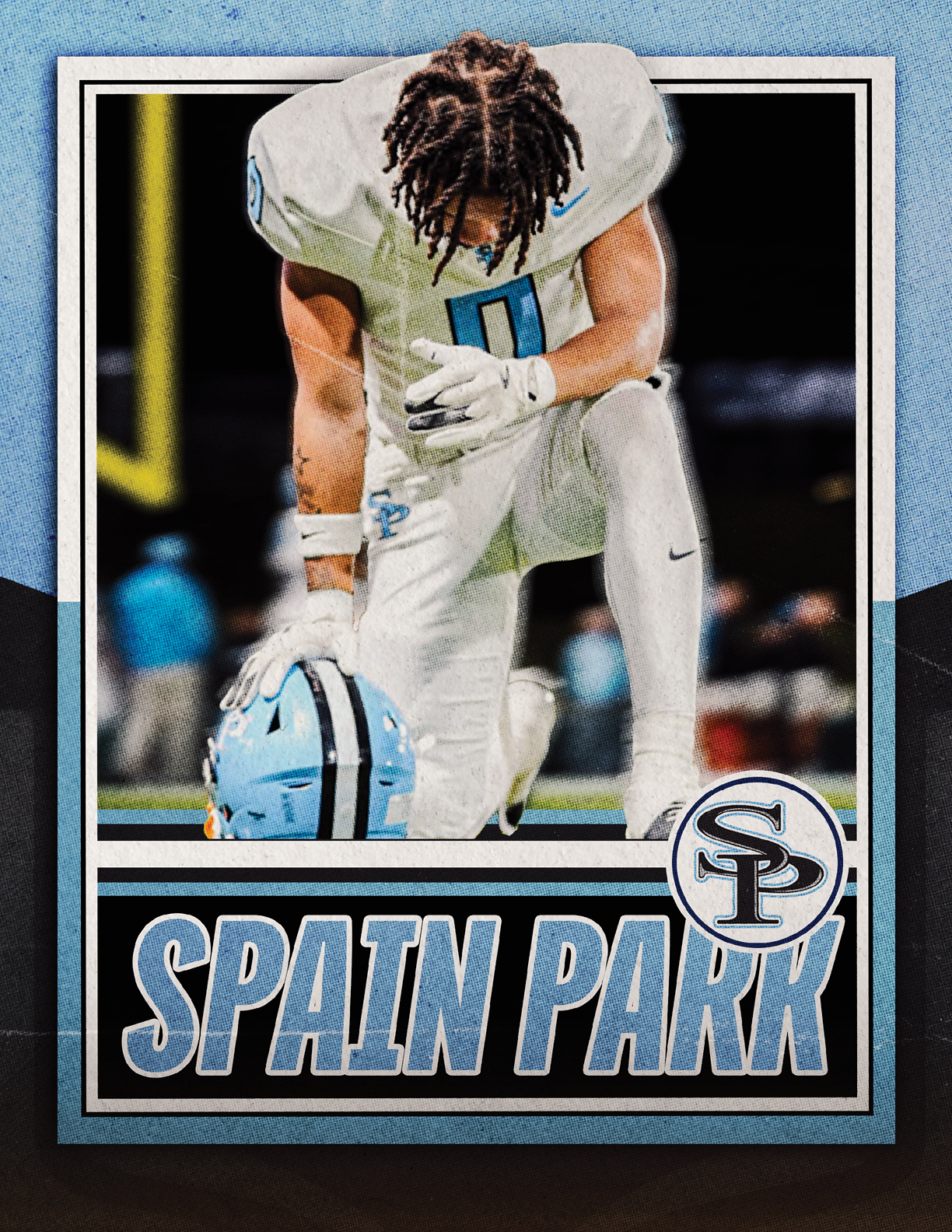 A person in a white football uniform kneels on one knee on a field holding a blue helmet with the text Spain Park and a logo in the foreground. Description generated by AI