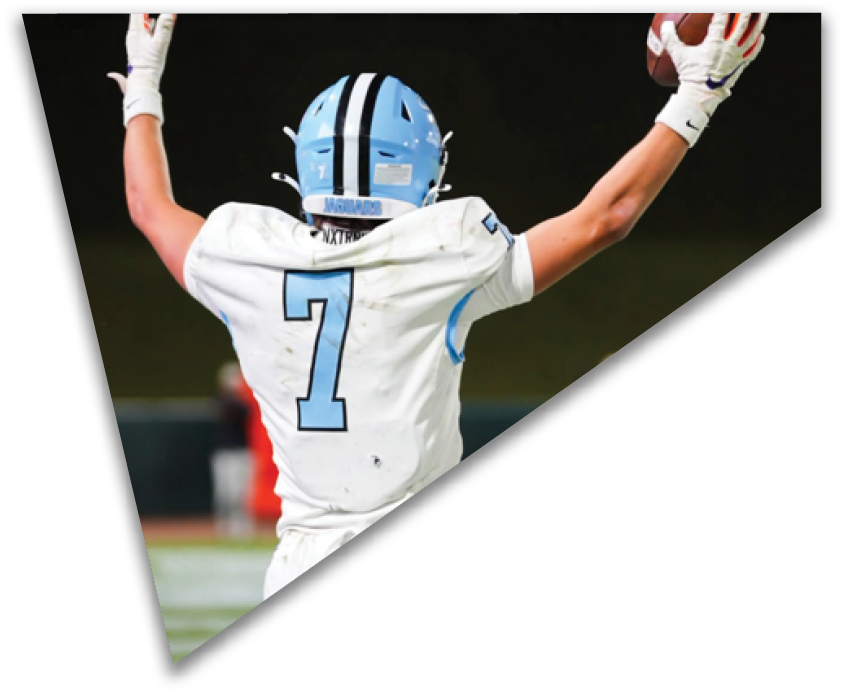 A person wearing a white sports uniform with the number seven on the back is raising their arms on a field. Description generated by AI
