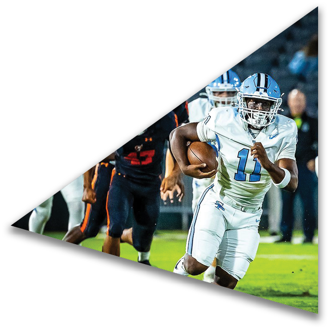 A person in a white football uniform with the number 11 is running with the ball while being chased by players in dark uniforms on a football field. Description generated by AI