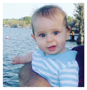 A baby is sitting in a person's arms, looking at the camera. AI generated content