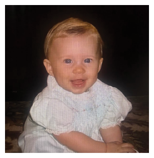 A young child is sitting on a rug, wearing a white shirt and white socks. The child is smiling and appears to be enjoying the moment. AI generated content