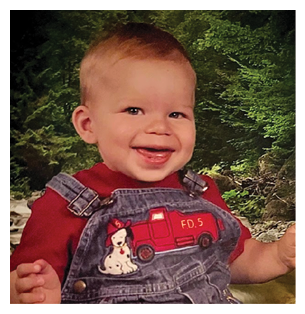 A young child wearing a red shirt and blue overalls is smiling and sitting in front of a green background. AI generated content