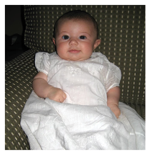 A baby wearing a white dress is sitting on a couch. AI generated content