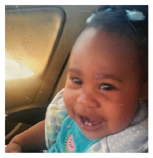 A young child is sitting in a car seat, smiling and wearing a blue and white shirt. AI generated content