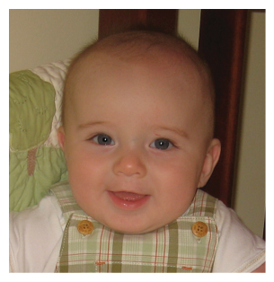 A baby with a green and white plaid bib is smiling and sitting in a high chair. AI generated content