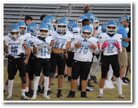 A group of young boys wearing football uniforms pose for a picture. AI generated content