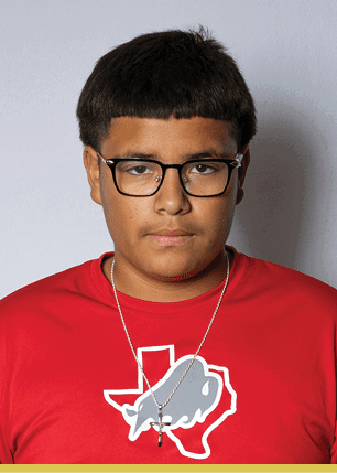 A young man wearing a white and black jersey with the number 14 on it. Description generated by AI