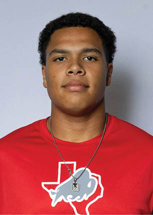 A young man wearing a white and black jersey with the number 14 on it. Description generated by AI