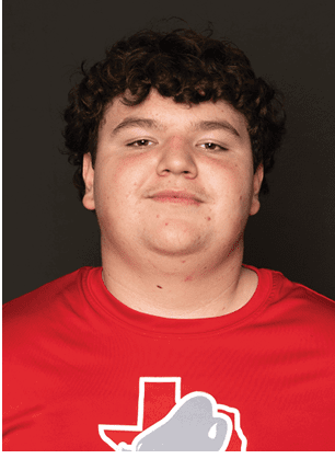 A young man wearing a white and black jersey with the number 14 on it. Description generated by AI