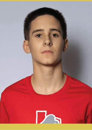 A young man wearing a white and black jersey with the number 14 on it. Description generated by AI