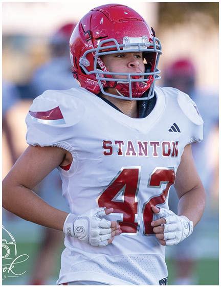 A football player wearing a blue jersey with the number 58 on it. Description generated by AI