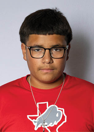 A young man wearing a white and black jersey with the number 14 on it. Description generated by AI