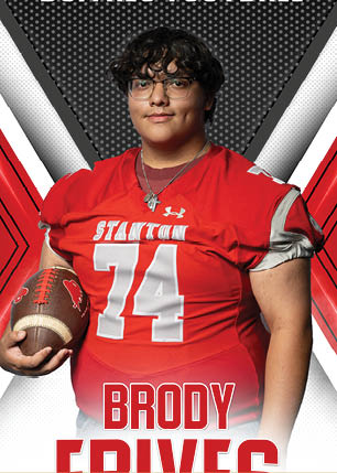 A young man wearing a white and black jersey with the number 14 on it. Description generated by AI