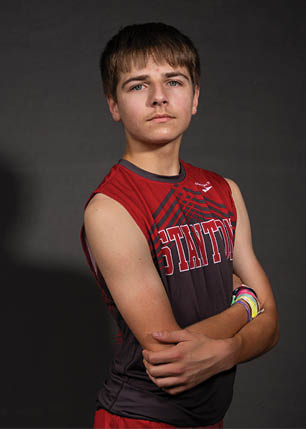A young man wearing a white and black jersey with the number 14 on it. Description generated by AI