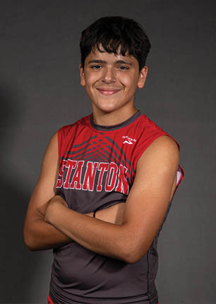 A young man wearing a white and black jersey with the number 14 on it. Description generated by AI