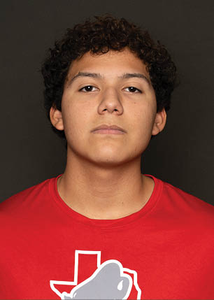 A young man wearing a white and black jersey with the number 14 on it. Description generated by AI