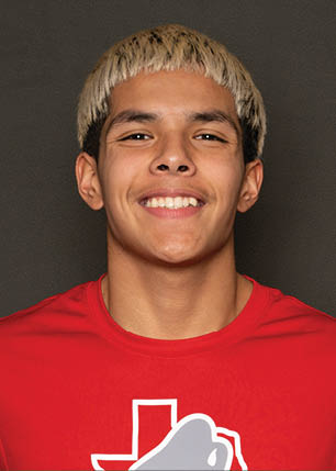 A young man wearing a white and black jersey with the number 14 on it. Description generated by AI