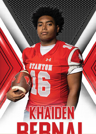 A young man wearing a white and black jersey with the number 14 on it. Description generated by AI