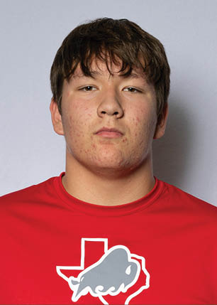 A young man wearing a white and black jersey with the number 14 on it. Description generated by AI